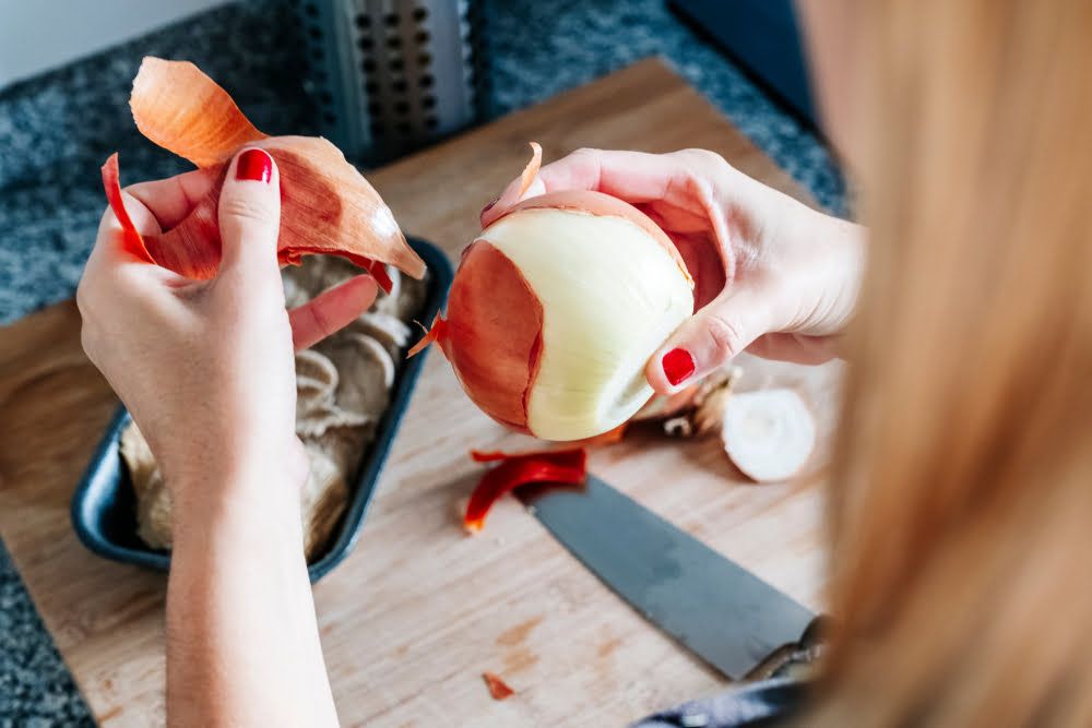 Woman peeling onion