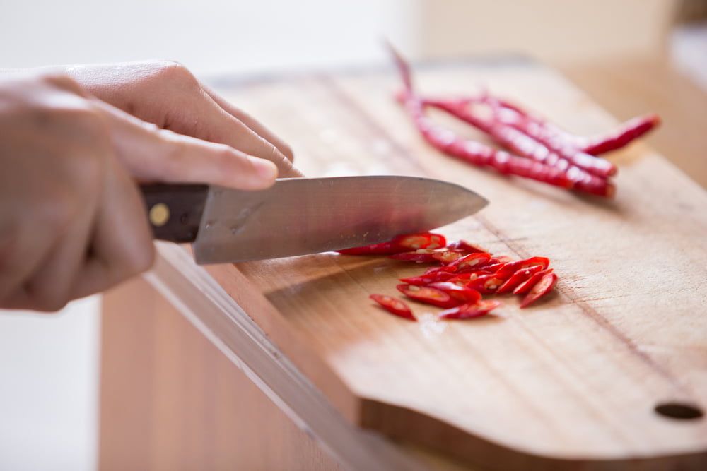 Slicing chillies on chopping board