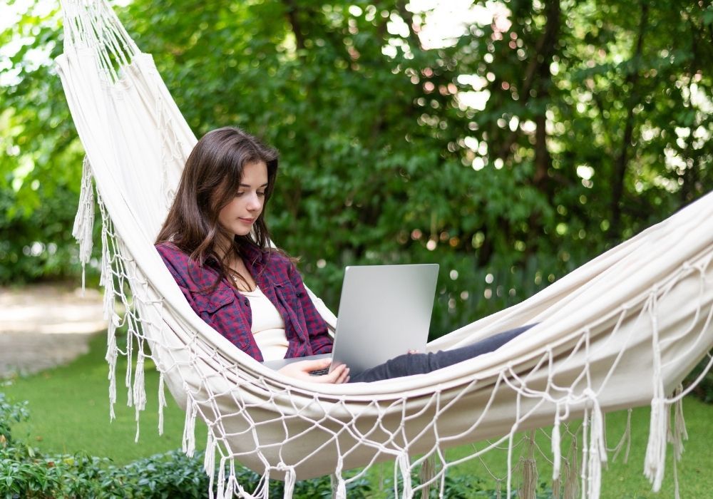 woman-with-laptop-in-a-hammock-in-garden