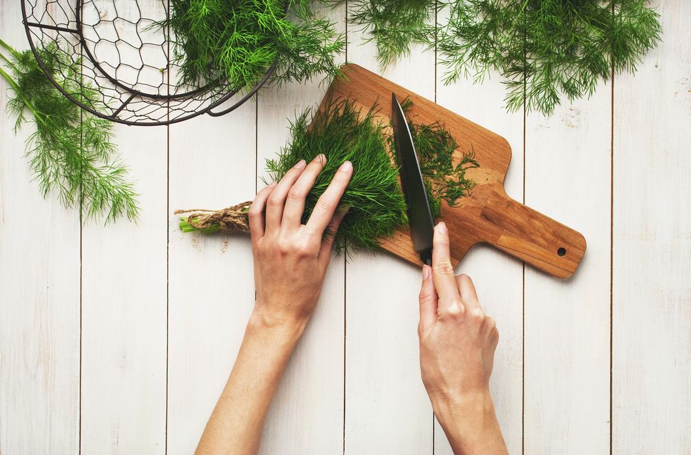 Woman chopping dill leaves